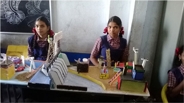 Students posing with their completed experiments, smiling and showcasing their scientific projects in a classroom or lab.